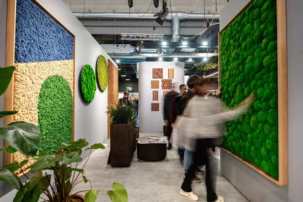 Des personnes regardent des installations modernes d'art vert dans une galerie.